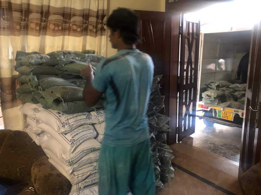 Man unloading flour from a rickshaw in pakistan during COVID-19 as part of a food donation program
