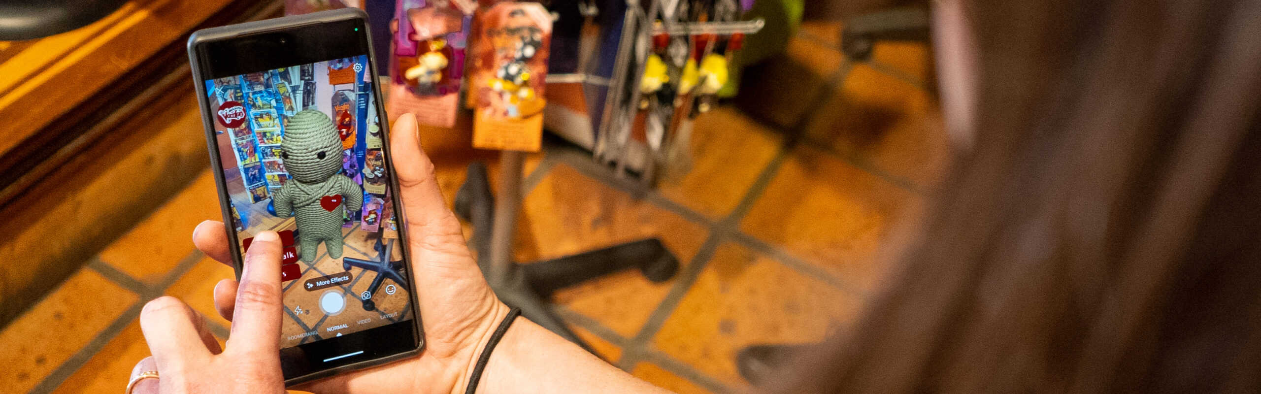 a hand holding a phone watching the voody AR experience