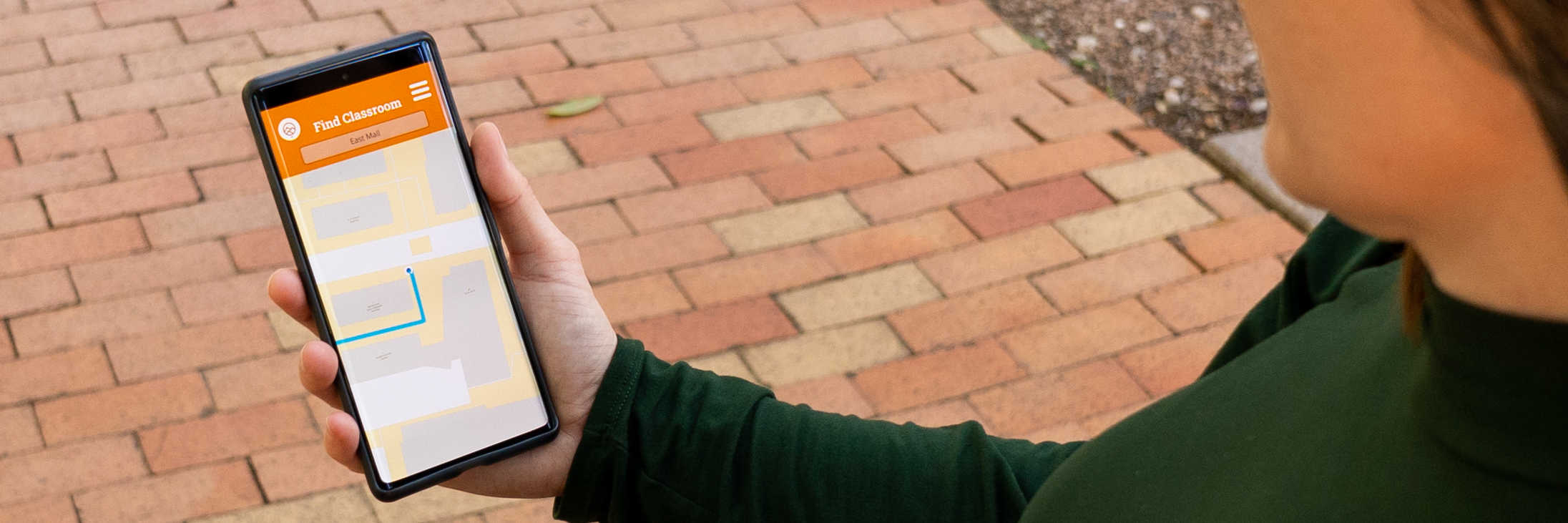A women holding a phone using the wayfinding feature of Cougy Campus mobile app